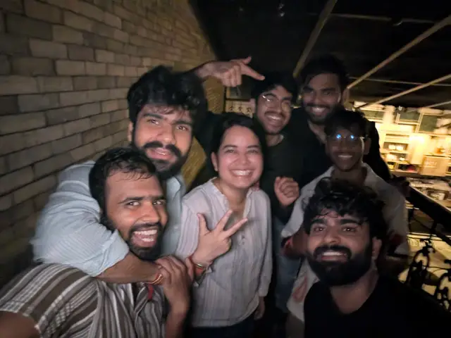 A late-night selfie against a brick wall, everyone mid-laugh